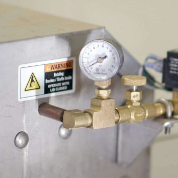 Metering valve pressure gauge on a Power Scrub Egg Washer